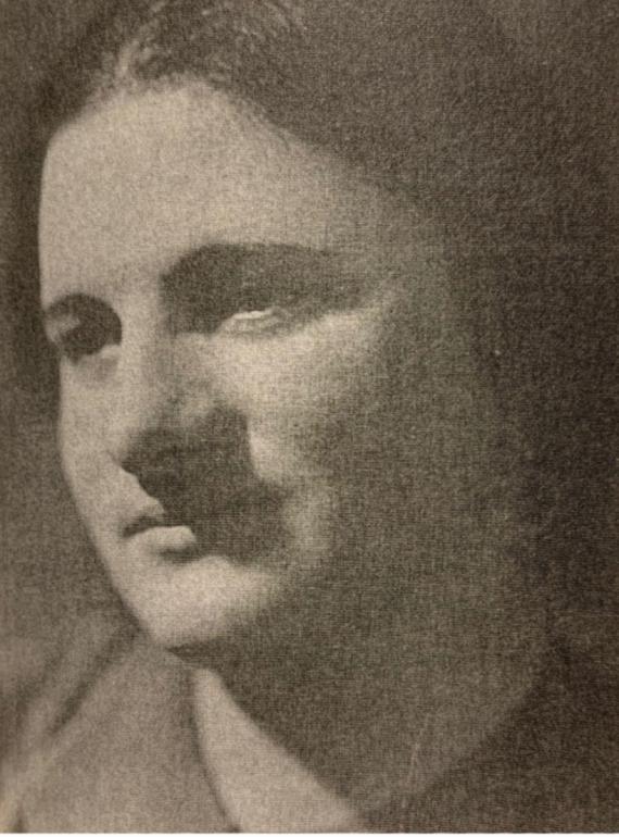 Ruth Hamburger looks past the camera on the right. She has a gentle expression on her face and is smiling slightly. The photograph is in black and white.