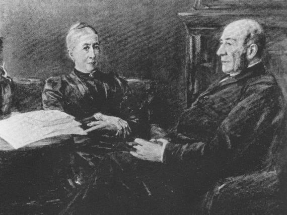 The black-and-white photograph of an oil sketch by Max Liebermann shows his parents sitting in a middle-class living room. They are wearing dark, restrained and austere-looking clothes. They appear to be about sixty years old.