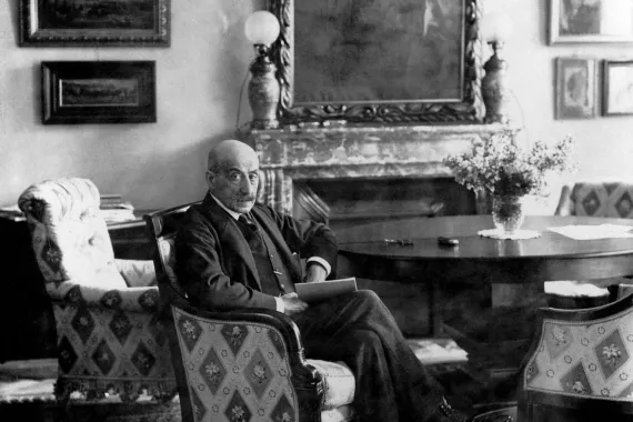 A black and white photograph shows Max Liebermann in a bourgeois interior in an upholstered armchair