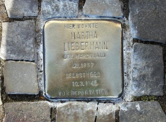 Ein sogenannter Stolperstein aus Bronze, der in das Gehwegspflaster eingelassen wurde, ist beschriftet mit Namen und Lebensdaten von Martha Liebermann