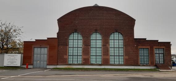 Frontal view of a red brick building with high windows