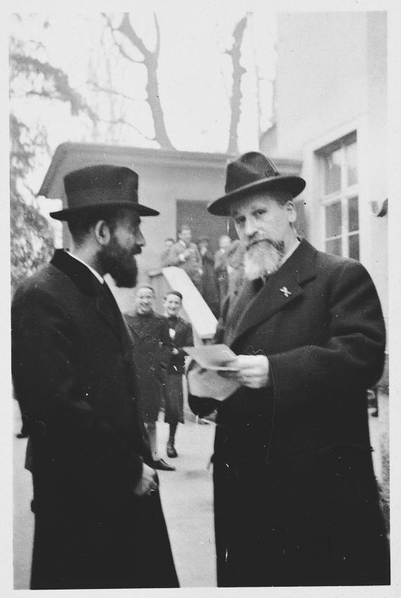 Two men in front of the Torah school building