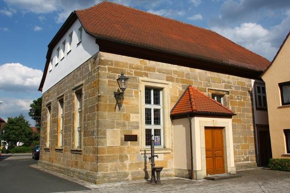 Sandstone building with sloping roof made of red roof tiles