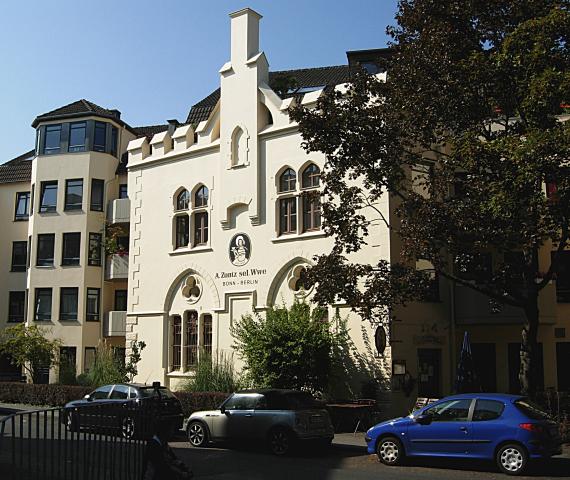 Neugotischer Giebel mit dem Logo der Kaffeerösterei: Frau mit Sonnenhut, darunter der Name A. Zuntz sel. Wwe Bonn - Berlin, die Abkürzungen stehen für selige Witwe und für die Ausbreitung über Bonn hinaus bis nach Berlin