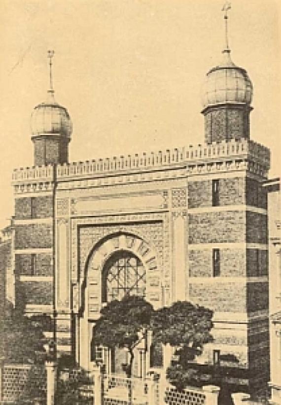 tall building with two towers on the sides and spherical domes