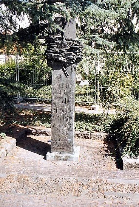 Memorial stone on paved road for the former synagogue at its location