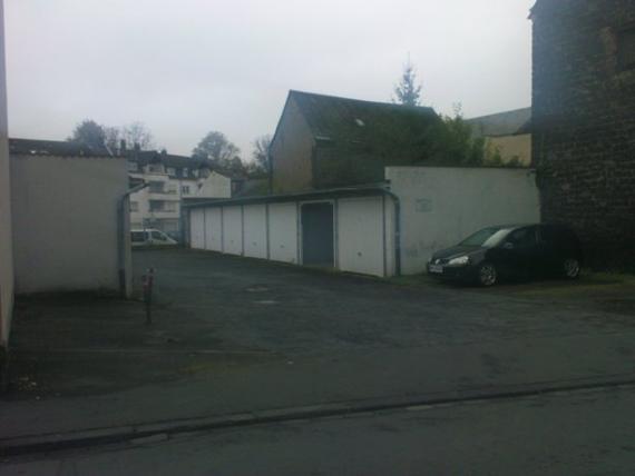 Blick auf eine Seitenstraße mit parkenden Autos und vermutlich eine Lagerhalle