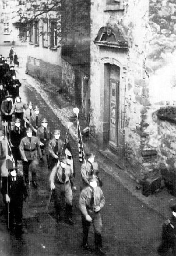 Vorbeimarsch der SA an der Synagoge in Sandhausen (rechts) um 1935