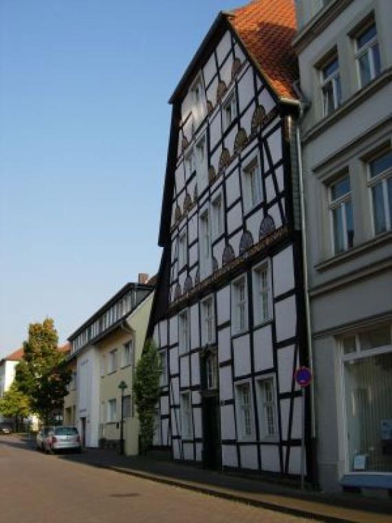 View of the stately half-timbered house in white with red roof and further the synagogue site