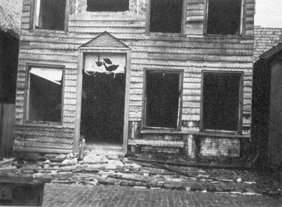 black and white picture of the deserted synagogue building. The door and the windows were unhinged and burned.