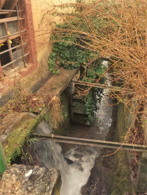 In the center of the picture, the Laudenbach falls almost four meters at the Berney Mill. It drives two adjacent mills, each with overshot mill wheels: the Berney Mill and the Diems Mill. Water is channeled over the mill wheels as needed, falling from above onto the blades to drive the mill wheels. The rear mill wheel of the Diems Mill is still preserved.