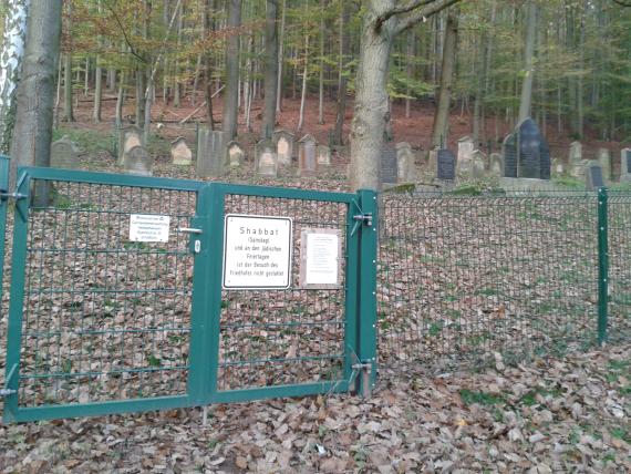 Eingangstür zu einem Friedhof im Wald