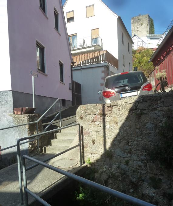 Two houses of the Juliusspitälischer Freihof. The original buildings were destroyed in the war, the houses are more recent. Above the keep of the Wertheim castle, at the bottom of the picture flows the stream, secured by railings.