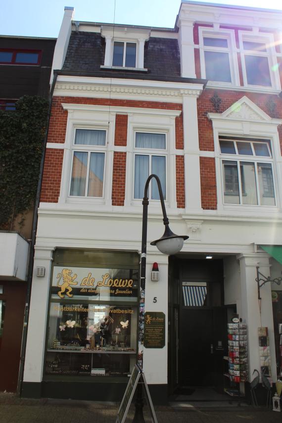 Two-story row house with a street lamp in front of it.