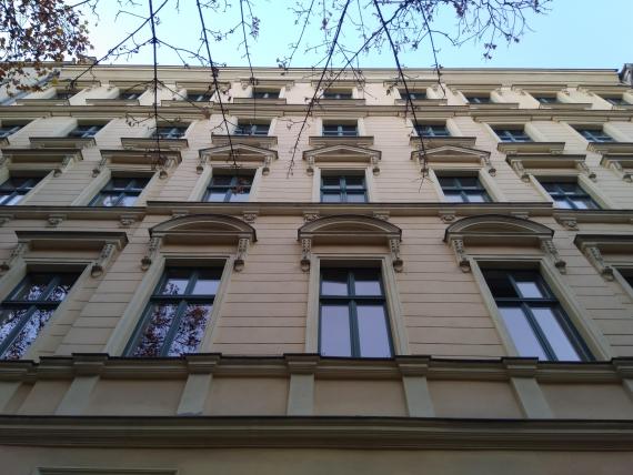 Blick von unten nach oben, entlang einer Hausfassade mit vielen Fenstern