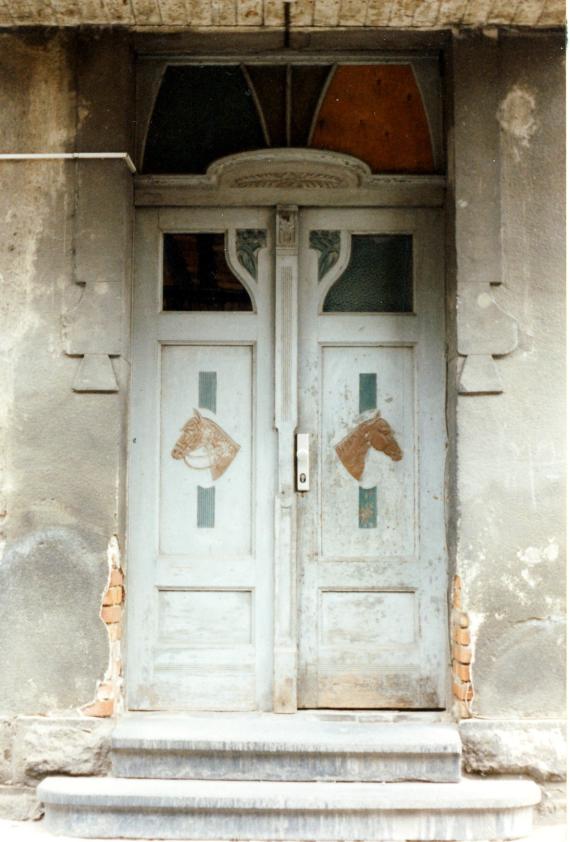 Art Nouveau style double-leaf front door with two carved horse heads