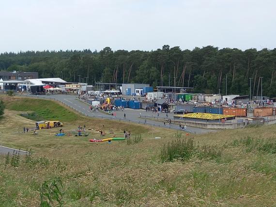 View from the slope of the Müllberg to the AWV administration building, the entrance area and the row of AWZ containers; in front of it, games for the 2024 summer festival